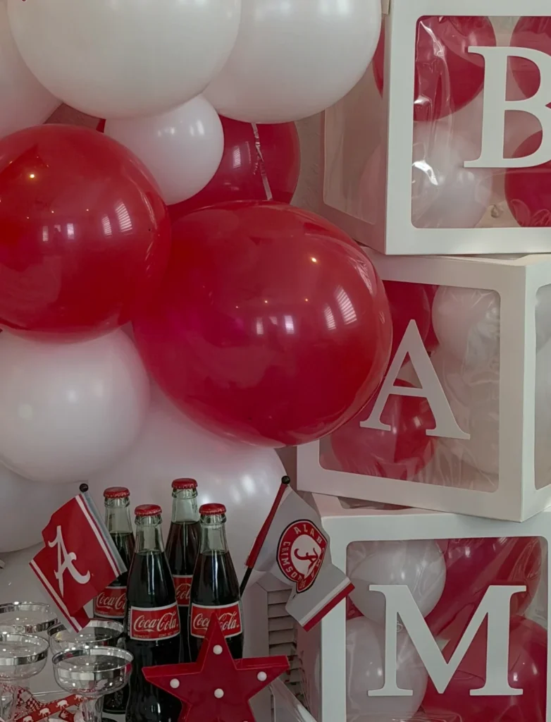 Alabama bed party with crimson and white balloons, B-A-M-A letter blocks and Roll Tide flags