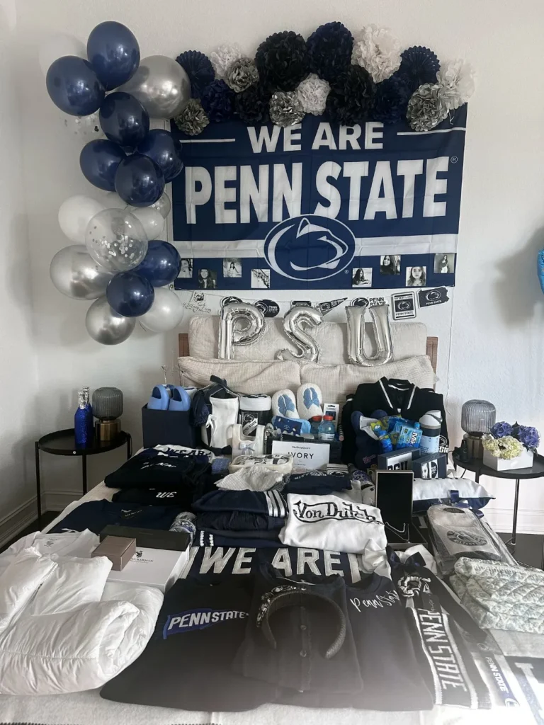 Penn State commitment bed party with navy and silver balloons, a We Are Penn State banner and PSU letters over the bed