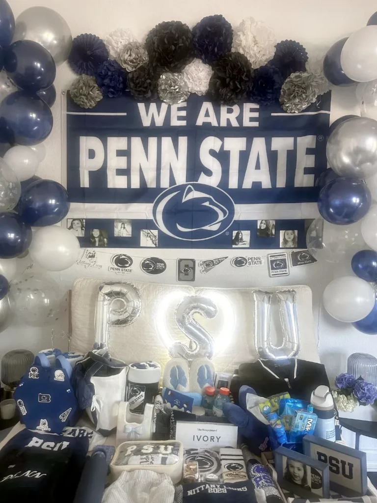PSU bed party with glowing marquee letters and Penn State gifts across the bed